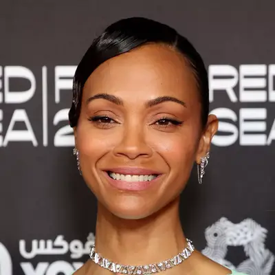 Zoe Saldana with glossy, side-swept low bun at the screening of 