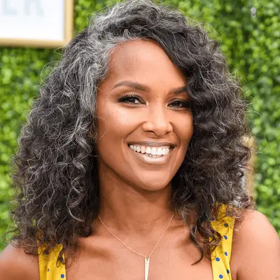 Mara Brock Akil wearing curly hair with gray streaks