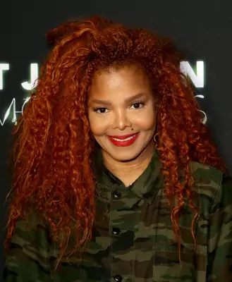 Janet Jackson with curly red hair on the red carpet