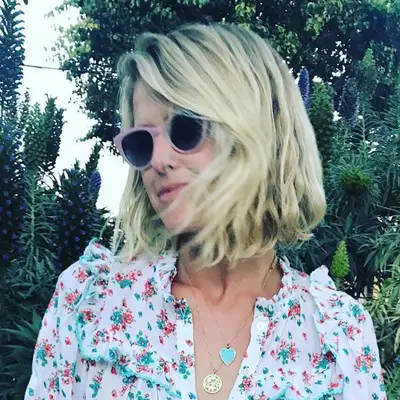 Creator with blonde tousled A-line bob haircut and pink sunglasses