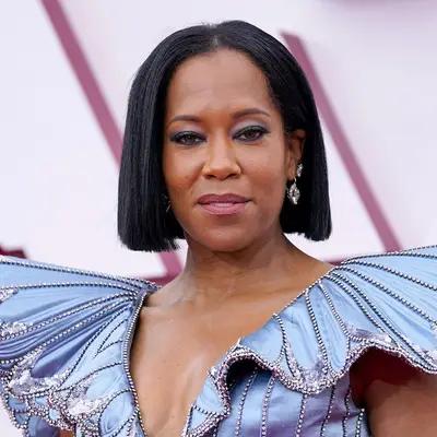 Regina King wears a sleek A-line bob hairstyle and blue gown with voluminous shoulders