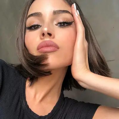 Olivia Culpo wears a tousled bob hairstyle and neutral glam makeup