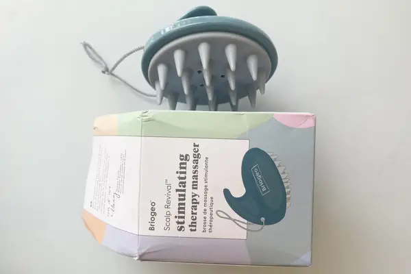 A person using the Denman Palm Styler for Detangling, Massaging & Styling on their scalp