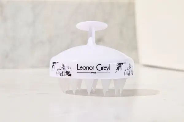 The Leonor Greyl Massaging Scalp Brush sitting on a counter