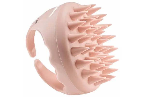 The Leonor Greyl Massaging Scalp Brush sitting on a counter
