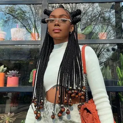 Woman with beaded box braids and Bantu knots at top