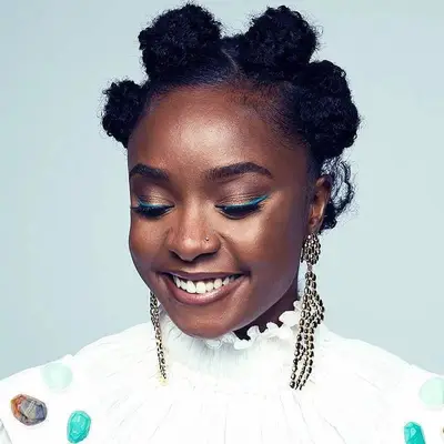 Kiki Layne wears large Bantu knots and teal eyeliner