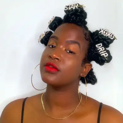 Woman with Bantu knot hairstyle featuring rhinestone word pins