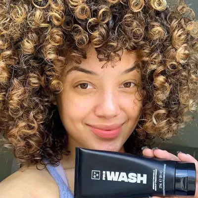 A woman with curly, dark blonde toasted coconut hair