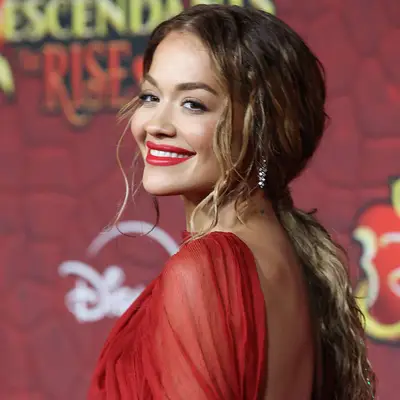 Rita Ora with brown and blonde hair in a low ponytail at the 