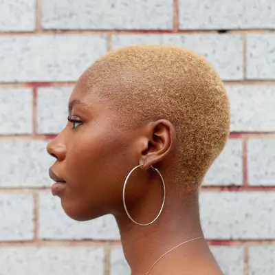 A woman with buzzed iced latte blonde hair