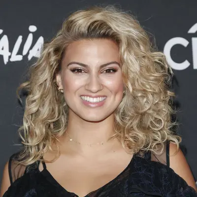 Tori Kelly wears her signature golden blonde natural curls