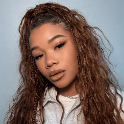 storm reid wearing copper knotless braids with half up half down style