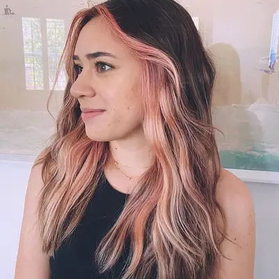 Woman with dark hair and pink face-framing pieces