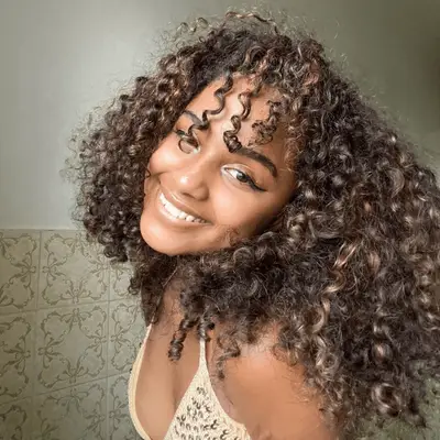 Tyla with shoulder-length spirals and wispy bangs