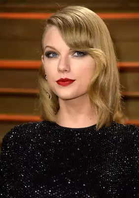 Taylor Swift with coiffed side fringe in black sparkle dress