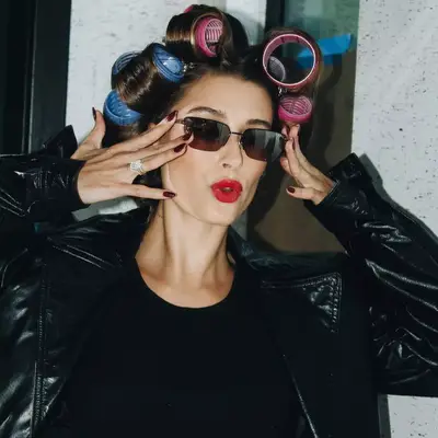 Hailey Bieber wearing sunglasses and Velcro hair rollers.