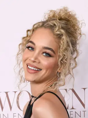 Jasmine Sanders with blonde curly hair in messy updo