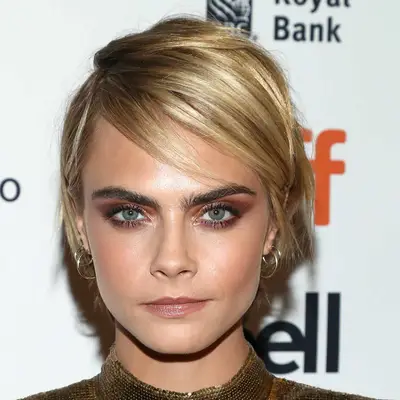 Cara Delevingne wears a grown-out, tousled pixie hairstyle
