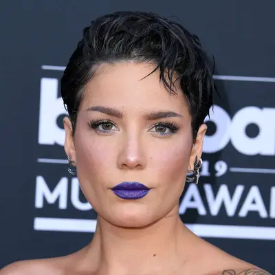 Halsey wears a wet look pixie hairstyle and purple lipstick