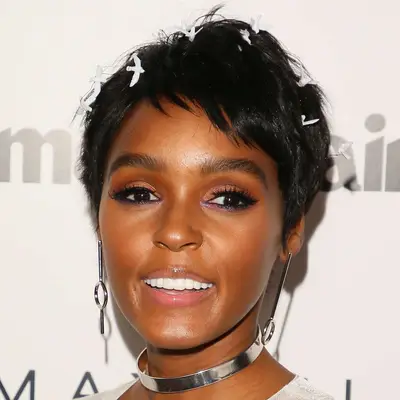 Janelle Monae wears a short pixie hairstyle with white butterfly clips