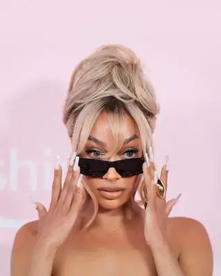 Lala Anthony with face-framing bangs and messy updo 