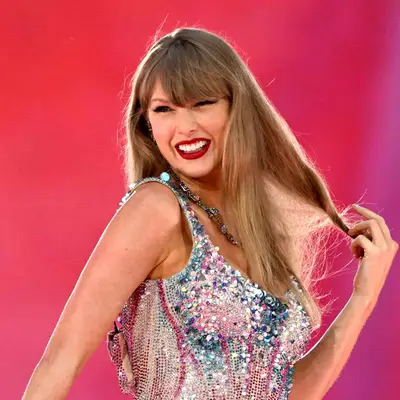 Taylor Swift performing at Eras Tour in cat eye makeup and red lipstick