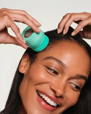 Model applying Briogeo Style + Treat Dry Shampoo Puff