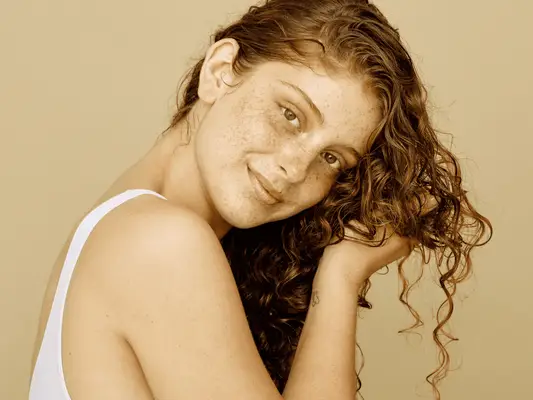 Close up of a woman scrunching her hair