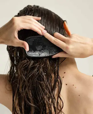Woman combing through wet hair