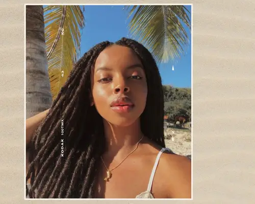 woman on the beach with sun shining on her face 
