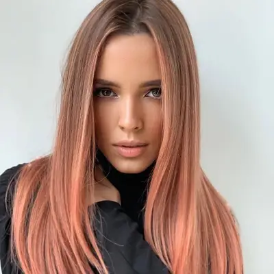 Woman with sleek, straight hair with peach highlights