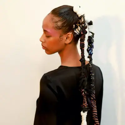 Back view of model with two ribbon-wrapped ponytail braids
