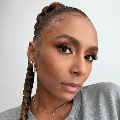 Janet Mock wears a slicked-back ponytail braid with laid baby hairs