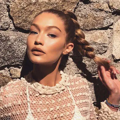 Gigi Hadid wears a braided ponytail hairstyle in natural sunlight