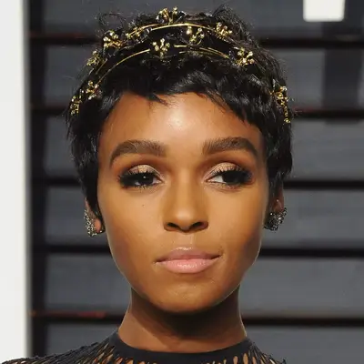 Janelle Monae wears a delicate double wired gold headband with bejeweled flowers in her short, shoppy pixie cut
