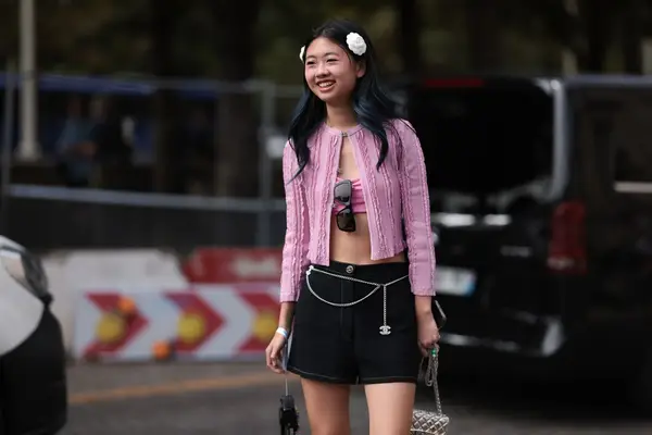 Woman wearing a pink sweater and two white flowers in her hair