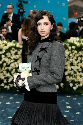Clairo poses on the Met Gala 2025 Red Carpet holding a cat bag and showing off a dimensional Betty Boop Bang.