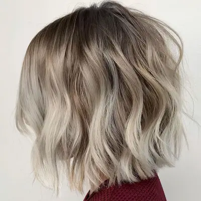 Side view of cool-toned blonde to platinum ombre long bob hairstyle