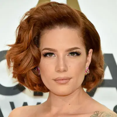 Halsey wears a side-parted wavy copper bob