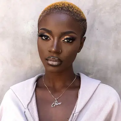 Woman with short natural hair with platinum-toned to golden ombre