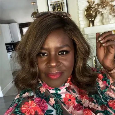 Retta wears a long bob blowout hairstyle with subtle caramel highlights