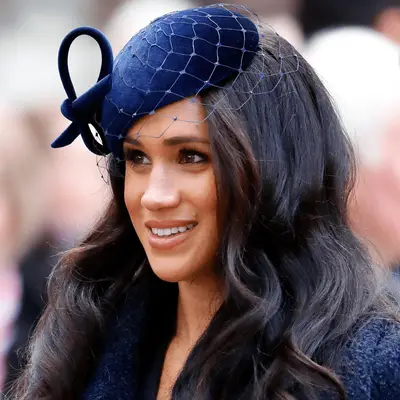 meghan markle wearing bouncy curls and blue fascinator
