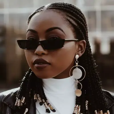 Woman with skinny sunglasses and braided, beaded hair
