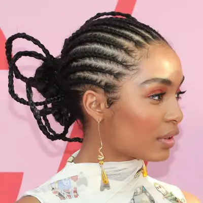 Yara Shahidi wears feed-in braids in an avant-garde center bun style