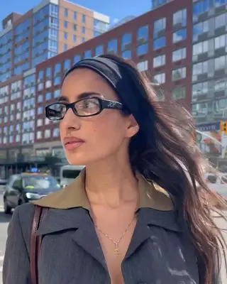 Model wearing glasses and a black headband
