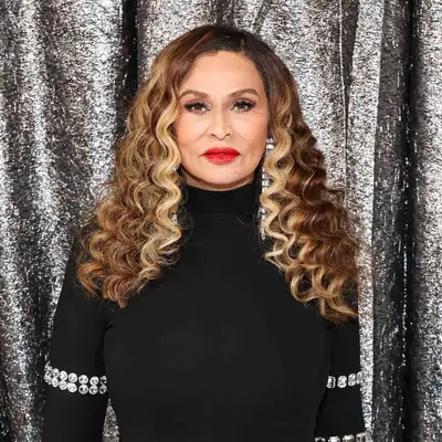 Tina Knowles wearing wand curls with caramel blonde highlights