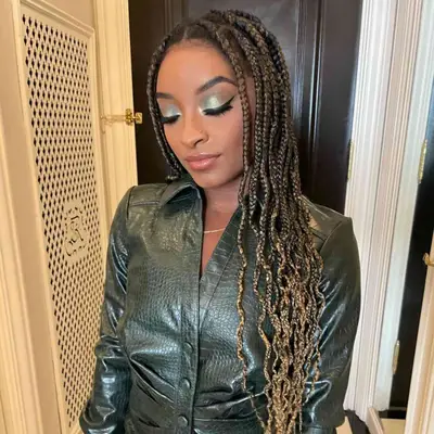 Simone Biles with braided-in blond highlights in her brown hair.