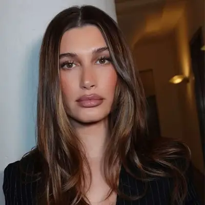 Hailey Bieber with dimensional brunette hair.