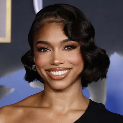 Lori Harvey wears her bob in a heavily curled style with decorated edges